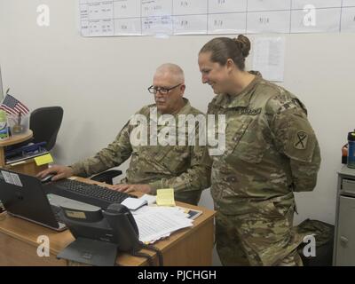 Us-Armee Sgt. Maj. Samuel Farley, die Logistik noncommissioned Officer verantwortlich für konsequenten Schloss 2018 und Maj. Emily Lynds, das Personal Officer verantwortlich für RC 18, beide zu 218 Manöver Verbesserung Brigade, South Carolina Army National Guard zugeordnet, Verteidigung Travel System Einnahmen im täglichen Betrieb in Boleslawiec, Polen, 20. Juli 2018 diskutieren. Farley feierte seinen 40-jährigen Karriere Jahrestag in der Army National Guard, während in Polen zur Unterstützung der Atlantischen Lösung bereitgestellt. Stockfoto