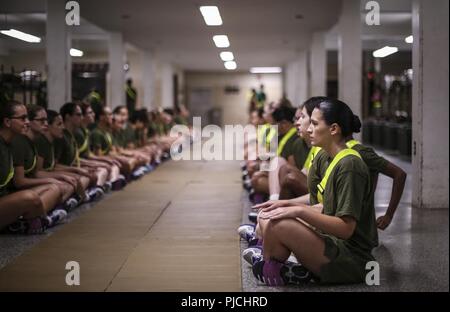 Us Marine Corps Rekruten mit Platoon 4038, Papa, 4 Recruit Training Bataillon, das Knirschen Teil ihrer ursprünglichen Stärke Test auf Parris Island, 20. Juli 2018 auszuführen. Die minimale physische Anforderungen für Frauen, die eine Ausbildung beginnen, sind 44 Knirschen in zwei Minuten, 1 Pull-up ohne Zeitangabe oder 15 Push-ups in zwei Minuten, und ein 1,5-Meile laufen in 15 Minuten. Heute, rund 19.000 Rekruten kommen auf Parris Island jährlich für die Chance, United States Marines werden durch dauerhafte 13 Wochen strenge, transformative Training. Parris Island ist die Heimat der Einstiegsklasse eingetragen Stockfoto