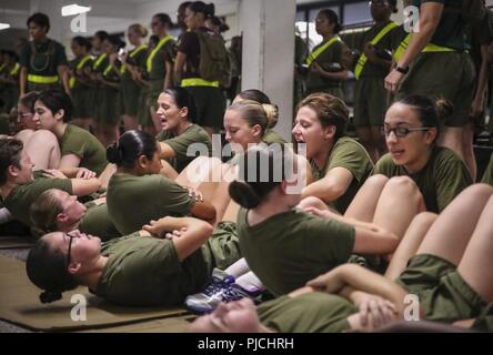 Us Marine Corps Rekruten mit Platoon 4038, Papa, 4 Recruit Training Bataillon, führen Sie Knirschen in der Anfangsphase ihrer Stärke Test auf Parris Island, 20. Juli 2018. Die minimale physische Anforderungen für weibliche Rekruten zu beginnen mit dem Training sind 44 Knirschen in zwei Minuten, 1 Pull-up ohne Zeitangabe oder 15 Push-ups in zwei Minuten, und ein 1,5-Meile laufen in 15 Minuten. Heute, rund 19.000 Rekruten kommen auf Parris Island jährlich für die Chance, United States Marines werden durch dauerhafte 13 Wochen strenge, transformative Training. Parris Island ist die Heimat von Entry-level-Soldaten Training für 49 p Stockfoto