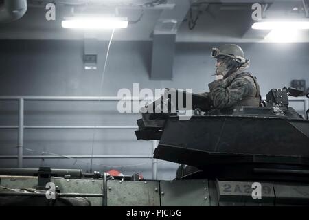 ROTA, Spanien (Juli 20, 2018) eine US Marine Corps Sgt. Cody Ton, ein Assistent, der abschnittsleiter zugeordnet zu den Angriff Amphibienfahrzeug Platoon, Fox, Bataillon Landung Team, 2.BATAILLON, 6 Marine Regiment, 26 Marine Expeditionary Unit (MEU), kehrt zum Harpers Ferry-Klasse dock Landung Schiff USS Oak Hill (LSD 51) nach Abschluss eines geplanten Abwaschbares in Rota, Spanien, 20. Juli 2018. Das Oak Hill, homeported in Virginia Beach, Virginia, und der 26. MEU leiten Marineoperationen im 6 Bereich der Flotte von Operationen. Stockfoto