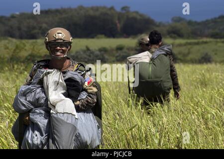 WAHIAWA, Hawaii (19 Juli 2018) - Mitglied der Philippinischen Marine Special Operations Group trägt seinen Fallschirm aus der Drop Zone während der Teilnahme in der Luft stecken Operations Training während der Rand des Pazifik (Rimpac) Übung, Juli 19. 25 Nationen, 46 Schiffe, 5 U-Boote, und etwa 200 Flugzeugen und 25.000 Angestellte beteiligen sich an Rimpac vom 27. Juni bis 2. August in und um die hawaiischen Inseln und Südkalifornien. Die weltweit größte internationale maritime Übung RIMPAC bietet eine einzigartige Ausbildung während der Förderung und Erhaltung der Genossenschaft rela Stockfoto