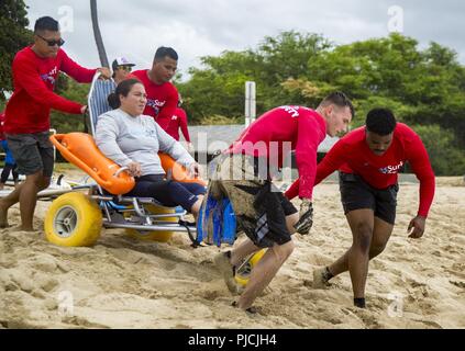 Us-Marines mit 3. Marine Regiment ein verwundeter Krieger in den Ozean bei verwundeten Krieger Tag im White Plaines Strand, Kapolei, Hawaii, Jan. 18, 2018. Die Veranstaltung bot sowohl aktive als Pflicht und Veteran verletzte Krieger, die Gelegenheit, den Ozean für den Tag zu genießen. Stockfoto