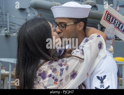 YOKOSUKA, Japan (24 Juli 2018) Fachkraft für Lagerlogistik 2. Klasse Gregor Hernandez, aus New York, umfasst sein Ehegatte nach der Ankunft der Ticonderoga-Klasse geführte-missile Cruiser USS Antietam (CG54). Antietam freut - in den USA 7 Flotte Bereich für Maßnahmen zur Erhöhung der Sicherheit und Stabilität in der indopazifischen Region bereitgestellt. Stockfoto