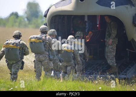 Us-Armee Fallschirmjäger zu 173Rd Airborne Brigade zugeordnet, zusammen mit britischen, französischen, spanischen und italienischen Fallschirmjäger, an Bord eines 12 Combat Aviation Brigade CH-47 Chinook Hubschrauber für eine zerstreute Betrieb bei Julia Drop Zone in Pordenone Aviano, Italien, 19. Juli 2018. Die kombinierte Übung demonstriert den multinationalen Kapazitäten der zerstreuten Gemeinschaft und auf die Erhöhung der NATO operativer Standards und der Entwicklung von individuellen technischen Fertigkeiten konzentriert Stockfoto