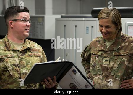 Staff Sgt. Andrew McIntosh, links, 347 Rettung Gruppe Training Manager, Schriftsatz Col. Jennifer Kurz, 23d Wing Commander, vor einer simulierten Übung während ein Eintauchen tour, 23. Juli 2018, bei Moody Air Force Base, Ga während der Immersion, Kurz besucht mit Survival, Evasion, Widerstand, Flucht (SERE) und medizinischen Spezialisten aus der 347 Operations Support Squadron (OSS). Die 347 OSS Rescue Training Center Häuser sowohl unabhängige Aufgabe medizinischer Techniker Sanitäter und SERE Spezialisten, deren Aufgabe es ist, Bahn und Flieger auszustatten, um in der Lage zu sein, um zu überleben und Leben zu retten, während im strengen Enviro Stockfoto