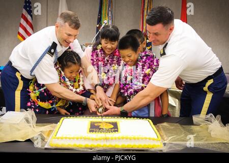 Von links, Oberstleutnant Matthew D. Lee, Kommandant der 2. Bataillon, 27 Infanterie Regiment, 3rd Infantry Brigade Combat Team, Schofield Kasernen, Hawaii, Nanaho Nakamura, Ayaka Kanzak, Yugen Izuka, 3 Kinder aus dem Waisenhaus, Battalion Command Sgt. Große Timothy Custis, und auf der Rückseite ist yuto Nakamura, das 4. Kind aus dem Waisenhaus schließen heraus die Begrüßungszeremonie, 24. Juli an Daniel K. Inouye International Airport, Honolulu, Hawaii durch Schneiden der Kuchen. Dies war der Beginn der 61 Auftreten von dieser langjährigen Tradition, hat nie aufgehört, egal was der hav-Bereitstellungen Stockfoto