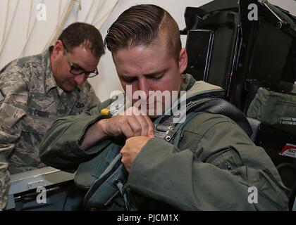 Tech. Sgt. Aaron Decremer, eine Waffen Direktor mit der 225Th Air Defence Squadron, zu den westlichen Air Defence Sektor zugewiesen, schnallen sich in einen Ausstieg Verfahren Trainer am 24. Juli, 2018 in Portland Air National Guard Base, Erz Decremer den Verfahren ist Lernen für die Demontage einer F-15D Adler als Teil seiner Ausbildung für seinen Flug air-achsenabschnitt Verfahren zu sehen. Stockfoto