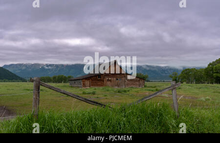 Scheune umrahmt von Zaun vor der Berge und Nebel Stockfoto