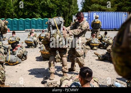 Grafenwöhr, Deutschland - SSG langen auf die 173Rd Airborne Brigade in der 54Th Brigade Ingenieur Bataillon zugeordnet führt Jumpmaster persönliche Inspektion (JMPI) auf einem Himmel Soldat, der aus einem Chinook auf Bunker DZ sprang. Stockfoto