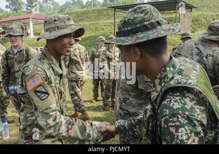 Soldaten mit dem 15 Royal Malay Regiment, Hände schütteln mit US-Armee Soldaten mit Charlie Company, 100-Bataillon, 442Nd Infanterie Regiment, US Army Reserve, während der Übung Keris Streik, Juli 24, 2018, Camp Senawang, Malaysia. Malaysischen Soldaten beweisen ihre Dschungel Taktiken zur Vorbereitung der Keris Streik jungle Bereich Training. Stockfoto