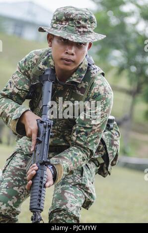 Der Soldat mit dem 15 Royal Malay Regiment Scans für simulierte Feinde während der Übung Keris Streik, Juli 24, 2018, Camp Senawang, Malaysia. Malaysischen Soldaten beweisen ihre Dschungel Taktiken zur Vorbereitung der Keris Streik jungle Bereich Training. Stockfoto