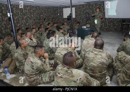 Soldaten mit dem 15 Royal Malay Regiment, und Charlie Company, 100-Bataillon, 442Nd Infanterie Regiment, US-Armee finden, überprüfen Sie die Definition der chemischen Kriegsführung, die während der Übung Keris Streik, Juli 24, 2018, Camp Senawang, Malaysia. Malaysische und US-Soldaten wurden gemeinsam die auf grundlegende Dekontaminierungsverfahren unterrichten und trainieren. Stockfoto