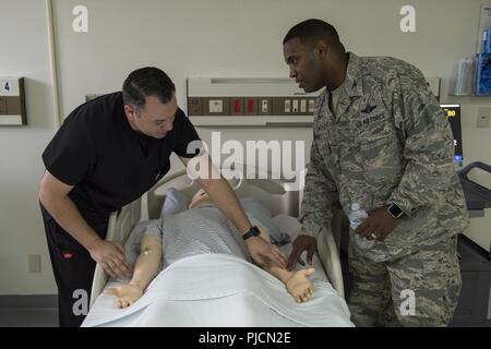 Dominic Trujillo-Hobbs, 374 medizinische Gruppe simulation Operator, zeigt Oberst Otis C. Jones, 374 Airlift Wing Commander, Puls Punkte auf der SimMan 3G Training Werkzeug während der 374 MDG immersion Tour an Yokota Air Base, Japan, 24. Juli 2018. Die Simulation Lab Züge mehr als 800 Studenten, Anhäufung von 1.800 Stunden Training auf einer jährlichen Grundlage, das Personal auf dem neuesten Stand über Ihre lebensrettenden Zertifizierungen. Stockfoto