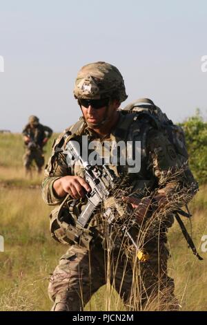 Us-Armee Pfc. Tyler Dunn, ein mortarman für die Zentrale und die Konzernzentrale, 2nd Battalion, 504Th Parachute Infantry Regiment zugeordnet, 1. Brigade Combat Team, 82nd Airborne Division, bewegt sich während des Betriebs der Brandmelder Teufel Sturm zu Mörtel, bei Holland Drop Zone in Fort Bragg, North Carolina, 19. Juli 2018. Betrieb Devil Storm ausgeübt Fähigkeit der Einheit zu kämpfen und überall mit kurzfristig zu gewinnen. Stockfoto