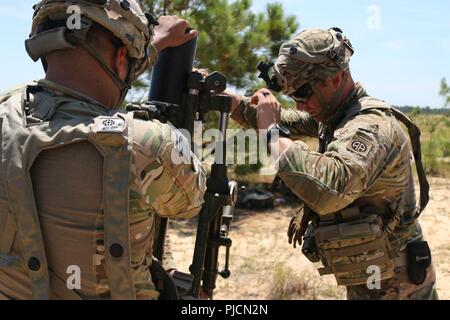 Us-Armee Pfc. Tyler Dunn (rechts), eine mortarman für die Zentrale und die Konzernzentrale, 2nd Battalion, 504Th Parachute Infantry Regiment zugeordnet, 1. Brigade Combat Team, 82nd Airborne Division, unterstützt die US-Armee SPC. James Quaile (links), eine M120 120 mm Mörser System während des Betriebs Teufel Sturm, bei Holland Drop Zone in Fort Bragg, North Carolina, 19. Juli 2018. Betrieb Devil Storm ausgeübt Fähigkeit der Einheit zu kämpfen und überall mit kurzfristig zu gewinnen. Stockfoto