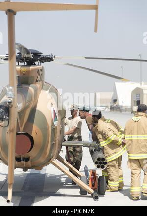 KABUL, Afghanistan (Juli 24, 2018) - ein afghanischer Air Force MD-530 Betreuer lehrt Afghanischen Luftwaffe Feuerwehrmänner, wie sicher die Flugzeuge während der MD-530 Egress übung Juli 24, 2018 zu deaktivieren, Kabul, Flügel, Afghanistan. Die zweitägige Übung konzentriert sich auf die unter gefährlichen Bedingungen und wie man sicher egress Piloten aus MD-530 s. Stockfoto