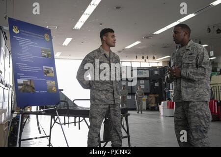 Senior Airman Alejandro Minaya, 374 medizinische Unterstützung Squadron Krieg Material reservieren Techniker, Schriftsatz Oberst Otis C. Jones, 374 Airlift Wing Commander, auf Kontingenz medizinische Material während der 374 medizinische Gruppe immersion Tour an Yokota Air Base, Japan, 24. Juli 2018. Die Tour gab dem neuen Wing Commander eine Chance zu Briefings von Führung und Experten hören, während Sie gleichzeitig die Flieger, die bilden die 374 MDG. Stockfoto