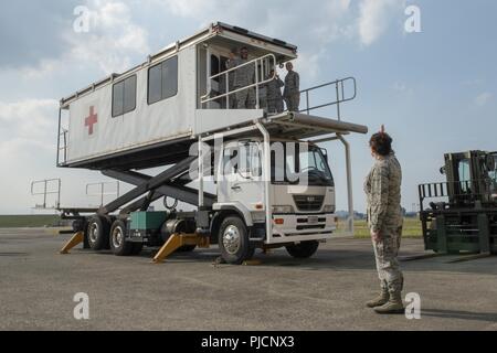 Oberst Otis C. Jones, 374 Airlift Wing Commander, Wellen, die von oben auf den Weg Patienten Staging System während der 374 medizinische Gruppe immersion Tour an Yokota Air Base, Japan, 24. Juli 2018. Die 374 MDG unterhält 55 Krieg finden materiel Projekte, einschließlich der Abteilung für die Verteidigung die größte Bewegung des Patienten los bestand. Stockfoto