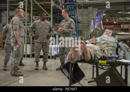 Staff Sgt. Shane Seite, 374 medizinische Unterstützung Squadron NCO verantwortlich für die Bewegung des Patienten, Schriftsatz Oberst Otis C. Jones, 374 Airlift Wing Commander, über Yokota's Bewegungen des Patienten während der 374 medizinische Gruppe immersion Tour an Yokota Air Base, Japan, 24. Juli 2018. Die 374 MDG unterhält 55 Krieg finden materiel Projekte, einschließlich der Abteilung für die Verteidigung die größte Bewegung des Patienten los bestand. Stockfoto