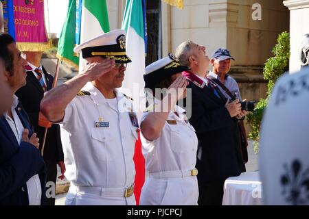 VADM Franchetti und CDR Cordero Salut zu Ehren der Soldaten, die das ultimative Opfer während der Schlacht von Ponte Dirillo und Operation Husky gemacht. Die Veranstaltung markierte den 75. Jahrestag der Operation Husky und der Beginn der italienischen Kampagne. Es war die größte Amphibische Operation des Zweiten Weltkrieges in Bezug auf die Größe der Landing Zone und die Anzahl der Geschäftsbereiche an Land setzen an diesem ersten Tag. Dieser zog Truppen von der Westfront und direkt an den Erfolg des D-Day in der Normandie beigetragen. Stockfoto