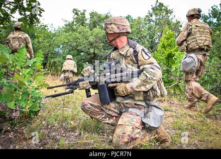 Pfc. Austen Swope, ein Martinsburg, Pennsylvania Eingeborener und ein Gunner zu Alpha Company, 2nd Battalion, 5th Cavalry Regiment, 1st Armored Brigade Combat Team, 1.Kavallerie Division, sieht hinten Sicherheit mit einem M249 Squad Automatic Weapon während einer Partie live-fire Übung, Selo, Bulgarien, 24. Juli 2018. Dieses Training ist zur Unterstützung der Atlantischen lösen, ein bleibendes Training übung zwischen der NATO und der US-Streitkräfte. Stockfoto