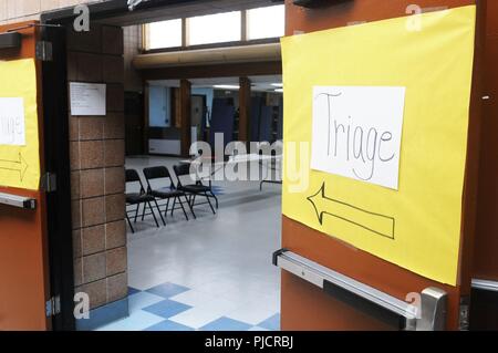 Handschriftliche zeichen Einweisung von Patienten in Richtung der Triage Zimmer für die ankommenden Patienten sitzt in der Cafeteria am Bug-O-Nay-Ge - Shig Schule in Bena, Minnesota Juli 17,2018. Im Rahmen einer Partnerschaft zwischen der US-Armee finden mit dem Leech Lake Band der Ojibwe und Cass Lake Indian Health Service, ca. 40 medizinische Fachleute, darunter Ärzte, Krankenschwestern und Krankenpfleger, Krankenschwester, Ärzte, Zahnärzte, Zahntechniker und zur Bekämpfung der Mediziner von der 7218th medizinische Unterstützung Einheit aus Louisville, Kentucky, sind die no-cost Health Care Services zu Personen an der Schule Stockfoto