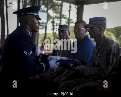 Us Air Force Airman 1st Class La Anthonia Alston, Mitglied der Hurlburt Field Ehrengarde, stellt eine amerikanische Flagge zu einem simulierten nächsten Angehörigen während einer ehrengarde Diplomverleihung an hurlburt Field, Florida, 13. Juli 2018. Dies war der erste Hurlburt Field Ehrengarde Abschlussfeier ein voller Ehrungen Beerdigung, die erlaubt Absolventen präsentieren die Ergebnisse ihrer zweiwöchigen Training zu bieten. Stockfoto