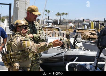 SAN DIEGO (24. Juli 2018) Küstenwache Chief Petty Officer Moises Guerrero (links), einen bootsmann Mate mit der Coast Guard Maritime Security Response Team - West (MSRT-West), erklärt die Funktionen der 33-Fuß-special purpose Handwerk - Strafverfolgungsbehörden zur Marine hinten Adm. David Welch, Commander, Naval Task Force 177, Oberfläche und Mine Warfighting Development Center, 24. Juli bei Coast Guard Sektor San Diego. MSRT-West Besatzungsmitglieder sind die Teilnahme an einer Übung im Rahmen des südlichen Kalifornien Komponente des Randes des Pazifik (Rimpac). 25 Nationen, 46 Schiffe und fünf U-Boote, abou Stockfoto