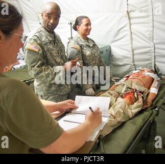 Us-Armee Soldaten zu Buchen 228th Combat Support Hospital zugewiesen, basierend aus San Antonio, Texas, für die medizinische Versorgung für eine simulierte Patienten während der Global Medic CSTX 91-18-01, am Fort Hunter Liggett, Kalifornien, 21. Juli 2018. CSTX 91-18-01 ist ein Kampf Support Training übung, die sicherstellt, dass America's Army Reserve Einheiten und Soldaten ausgebildet sind und bereit, auf kurze bereitstellen - Bekanntmachung und fähig, Bekämpfung bereit, und tödlichen Fähigkeiten zur Unterstützung der Armee und unsere gemeinsamen Partner überall in der Welt. Stockfoto