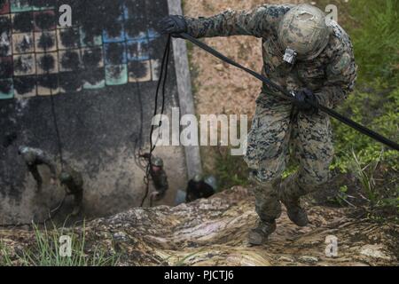 Lance Cpl. Antonio Gonzalezrueda, ein rifleman mit Echo Company, Bataillon Landung Team, 2nd Battalion, 5th Marines, rappels während ein Seil unterstützt Bewegung praktische Anwendung im Jungle Warfare Training Center, Camp Gonsalves, Okinawa, Japan, 24. Juli 2018. Gonzalezrueda, ein Eingeborener von San Marcos, Kalifornien, von der Rekrutierung der Unterstation Oceanside, bevor sie für die Grundausbildung im August 2016. Die Marines ausgebildet an Jwtc für eine bevorstehende Patrouille der indopazifischen Region wie der Bodenkampf Element für die 31 Marine Expeditionary Unit vorzubereiten. Die 31. MEU, das Marine Corps' Stockfoto