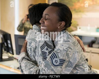 Command Chief Master Sgt. Ericka Kelly, Air Force Reserve Command, Umarmungen Staff Sgt. Courtnie Flippen, 413 Aeromedical Staging Squadron optometrie Techniker, 14. Juli 2018, bei Robins Air Force Base, Ga. Kelly präsentiert Flippen mit einer Münze und anerkannten Ihr für ihre engagierte Arbeit mit den 413 ASTS. Stockfoto