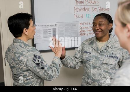 Command Chief Master Sgt. Ericka Kelly, Air Force Reserve Command, gibt eine fünf bis Staff Sgt. Trieshia Thornton, 413 Aeromedical Staging Squadron medizinischer Techniker, 14. Juli 2018, bei Robins Air Force Base, Ga. Kelly besucht 413 ASTS Bürger Flieger ein besseres Verständnis für Ihre Sendung zu erhalten. Stockfoto