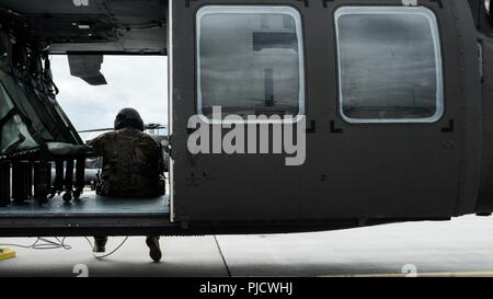 LIELVARDE AIR BASE, Lettland (9. Juli 2018) Eine UH-60 Blackhawk crewman mit Task Force Comanche Nord wartet auf den Auftrag zu starten. Aus Hubschraubern und Crew von 4 der US Army Combat Aviation Brigade, TF Comanche Norden stationiert ist in Lettland als Teil der Operation "Atlantic lösen. Von Lielvarde Air Base, Sie unterstützen Gastland Übungen sowie der NATO erweiterte Vorwärts Präsenz Battlegroup. Stockfoto