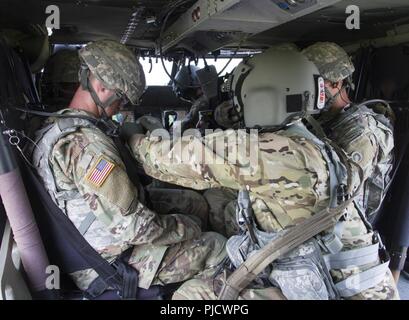 FORT KNOX, Ky. - Sgt. Brian Diggs, Crew Chief, im Aviation Brigade, rechts, sichert die Soldaten von der 1 Theater Sustainment Command in ein HH-60 M Krankenhaus Blackhawk während einer medizinischen Evakuierung (Medevac) Training, Juli 12. Die 1. TSC Soldaten gelernt, wie man zu errichten und einen einzelnen Kanal, Boden- und Radio-System verwenden, einen Unfall zu bewerten und taktische Sorgfalt ausgeführt, Anfrage MEDEVAC Unterstützung und Sicherheit von Flugzeugen sowie taktische Antenne Flugbetrieb. Stockfoto