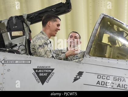 Master Sgt. Jakob Komenda, 51 Aircraft Maintenance squadron Specialist Section Chief, erklärt Airman 1st Class Zachary Smith, Abschnitt Support Techniker in 51 medizinischen Support squadron Commander, die Funktionen der verschiedenen Tasten im Cockpit einer Republik Fairchild A-10 Thunderbolt II am Osan Flughafen, der Republik Korea, 18. Juli 2018. Als Teil der Flieger, Flieger Schatten Mitglieder der Exchange Unit und über einige Aufgaben und Fähigkeiten seiner Karriere Feld erfahren. Stockfoto