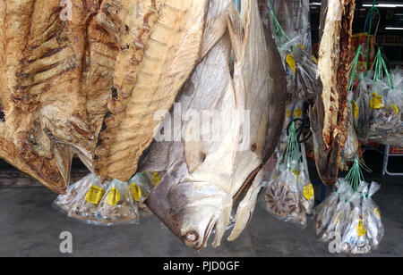Die gesalzene Getrockneter Fisch ist auf vom Verkäufer im Laden hing. In den Paketen oder durch Skalen Zu Verkaufen. Stockfoto