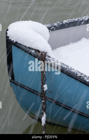 Schwere fallenden Schnee auf blau Boot vertäut Teil ausgefüllt mit Schnee, auf der Themse, Egham, Surrey Stockfoto