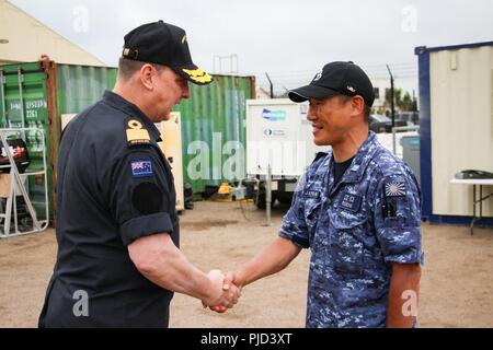 NAVAL BASE POINT LOMA, Kalifornien (17. Juli 2018) - Royal New Zealand Navy (RNZN) Commodore Tony Millar, maritime Komponente Commander und Vertreter der Chef der Marine (Neuseeland), schüttelt Hände mit einem Offizier von der Japan Maritime Self Defense Force mit Minenkrieg Task Force, die während eines Besuchs auf Naval Base Point Loma Juli 17. Millar besucht die Undersea mine Gegenmaßnahmen Task Group führte durch die RNZN während ihrer Teilnahme an den Rand des Pazifik (Rimpac) Übung im südlichen Kalifornien Bereich von Operationen. 25 Nationen, 46 Schiffe, 5 U-Boote, etwa 200 Luft Stockfoto