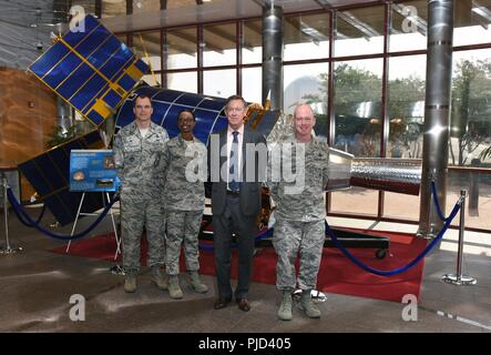 Von links nach rechts, Oberst Robert Hutt, 460Th Operationen Gruppenkommandant, Chief Master Sgt. Tamar Dennis, 460Th Space Wing eingehenden Befehl Chief, reg. John Hickenlooper von Colorado, und Oberst Troy L. Endicott, die 460Th Space Wing Commander, für ein Gruppenfoto vor dem Platz im Mission Control Station lobby Buckley Air Force Base, Colorado, 17. Juli 2018 gegründete Infrarot System stand. Während für die Station, Hickenlooper erhalten einen umfassenden Überblick über die Einsatzmöglichkeiten von der 460th SW, der globalen Infrarot Überwachung, Verfolgung und Raketen Warnung für Theater und h geliefert Stockfoto