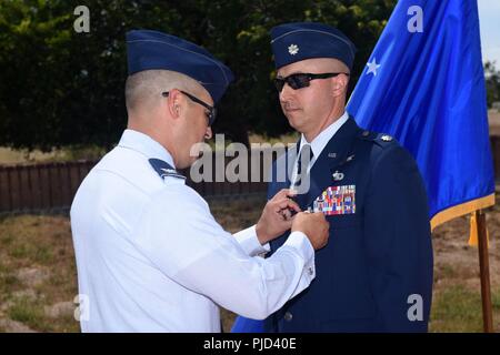 Oberst Curtis Hernandez, 30 Operationen Gruppenkommandant, präsentiert die Meritorious Service Medal, Oberstleutnant Max Coberly, 30 Bereich Management Squadron Commander auf der Vandenberg Air Force Base, Calif., am 10. Juli 2018. Coberly wurde die Medaille kurz nach der Inaktivierung des 30 RMS präsentiert. Stockfoto