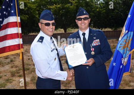 Oberst Curtis Hernandez, 30 Operationen Gruppenkommandant, präsentiert die Meritorious Service Medal, Oberstleutnant Max Coberly, 30 Bereich Management Squadron Commander auf der Vandenberg Air Force Base, Calif., am 10. Juli 2018. Coberly wurde die Medaille kurz nach der Inaktivierung des 30 RMS präsentiert. Stockfoto