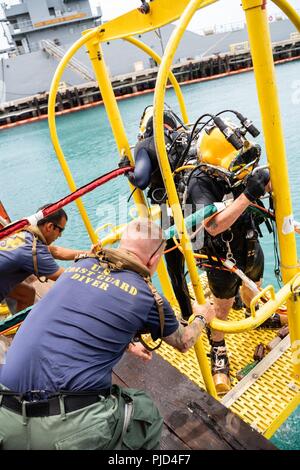 JOINT BASE Pearl Harbor - HICKAM, Hawaii (18 Juli 2018) Marine Taucher zu mobilen Tauchen retten (MDSU) 1 und Küstenwache Taucher zu regionalen Dive Locker Pazifik verhalten Oberfläche zugewiesen - gelieferte Taucharbeiten am Joint Base Pearl Harbor-Hickam während der Pacific Rim (Rimpac) Übung, Juli 18. 25 Nationen, 46 Schiffe, 5 U-Boote, über 200 Flugzeuge und 25.000 Angestellte beteiligen sich an Rimpac vom 27. Juni bis 2. August in und um die hawaiischen Inseln und Südkalifornien. Die weltweit größte internationale maritime Übung RIMPAC bietet eine einzigartige Ausbildung oppo Stockfoto