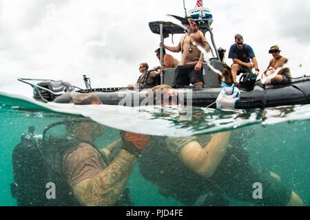 JOINT BASE Pearl Harbor - HICKAM, Hawaii (18 Juli 2018) Seabees Underwater Bau Team (UCT) 2 und Royal Canadian Navy Abstand Taucher, Tauchen Flotte Einheit, Durchführung Taucharbeiten für Unterwasser navigation Ausbildung bei Joint Base Pearl Harbor-Hickam während der Pacific Rim (Rimpac) Übung, Juli 18 zugewiesen. 25 Nationen, 46 Schiffe, 5 U-Boote, über 200 Flugzeuge und 25.000 Angestellte beteiligen sich an Rimpac vom 27. Juni bis 2. August in und um die hawaiischen Inseln und Südkalifornien. Die weltweit größte internationale maritime Übung RIMPAC bieten Stockfoto