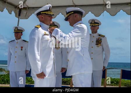 ASAN, Guam (19 Juli 2018) hinten Adm. Troy McClelland, Stellvertretender Kommandant für den Schiffsbau Kraft, Marine Expeditionary Befehl, präsentiert Kapitän Jeffrey Kilian mit einer Legion of Merit für seine Leistungen als Commodore des 30 Schiffbau Regiment während des Regiments Ändern des Befehls Zeremonie an der Krieg im Pazifik National Historical Park Asan Strand. Während der Zeremonie, Kapitän Steven Stasick entlastet Kilian als Commodore 30 NCR. Stockfoto