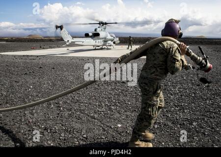 POHAKULOA TRAINING AREA, California (18. Juli 2018) US Marine Corps Cpl. Garrett Subik, ein Großteil der Spezialist mit Marine Wing Support Abteilung 24, bewegt sich eine Kraftstoffleitung auf dem Weg zu einem Landeplatz, um während eines Field Test für eine Expeditionary Mobile Kraftstoff Additization Fähigkeit System starten eine AH-1W Super Cobra Helikopter als Teil der Felge des Pazifiks (Rimpac) Übung an Pohakuloa Training Area, California, 18. Juli 2018. RIMPAC bietet hochwertige Ausbildung für Task-organisiert, leistungsfähigen Marine Air-Ground Task Force und erhöht die kritische Reaktion auf Krisen Fähigkeit der US-Marines in Stockfoto