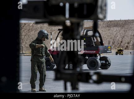 KANDAHAR AIRFIELD, Afghanistan (Juli 22, 2018) - einer afghanischen Luftwaffe Mannschaft Leiter eines UH-60 Black Hawk auf die 2 Flügel der afghanischen nationalen Armee bei Kandahar Airfield, Afghanistan zugewiesen, uncoils seine Mitteilung Kabel während einer Preflight Checkliste am 22. Juli 2018. Die Afghanische Air Crew sind ausgebildete fliegenden Missionen vom Briefing der Crew zu planen, einen formationsflug und ein Flight path route führen. Die Mission Der TAAC - die Luft wird zum Zug, beraten und afghanischen Partner unterstützen eine Professionelle, leistungsfähige und nachhaltige Afghanischen Luftwaffe zu entwickeln. Stockfoto