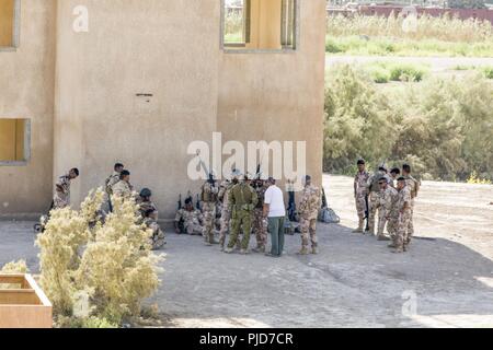 Eine australische Armee Trainer, mit Task Group Taji, Schriftsatz eine Gruppe von irakischen Soldaten während urban Operations Training mit irakischen Armee 2nd Battalion, 59th Brigade im Camp Taji, Irak, 17. Juli 2018. Durch beschleunigte Erfolge gegen ISIS im Jahr 2017 aktiviert, Koalition Unterstützung für unsere Partner entwickelt, wie wir unsere Partner bei der Bereitstellung von Sicherheit, die Stabilisierung unterstützen. Stockfoto