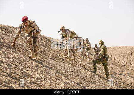 Australische Armee Cpl. Perrie Irwin, eine Aufgabengruppe Taji Trainer, beobachtet, irakische Soldaten Fortschritt zu einer Unterstützung durch Feuer Position während des Urban Operations Training mit irakischen Armee 2nd Battalion, 59th Brigade im Camp Taji, Irak, 17. Juli 2018. Durch beschleunigte Erfolge gegen ISIS im Jahr 2017 aktiviert, Koalition Unterstützung für unsere Partner entwickelt, wie wir unsere Partner bei der Bereitstellung von Sicherheit, die Stabilisierung unterstützen. Stockfoto