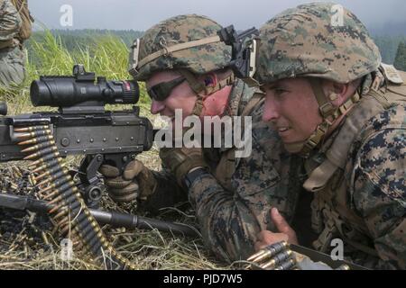 Staff Sgt. Dallas Allen und Lance Cpl. Daniel Davies mit Bataillon Landung Team, 2nd Battalion, 5th Marines, 31 Marine Expeditionary Unit, Firma F, Feuer ein M240B medium Maschinengewehr am Lager Fuji, Japan, 16. Juli 2018. Marines mit Firma F ausgebildet in Japans Gelände mit Manöver unter Feuer Taktiken zu betreiben. Die 31. MEU, das Marine Corps' nur kontinuierlich vorwärts - bereitgestellt MEU, bietet eine flexible Kraft bereit, eine breite Palette von militärischen Operationen auszuführen. Stockfoto