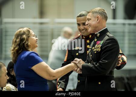 Us Marine Corps Colonel Russell A. Blauw stellvertretender Zweig Kopf, Aviation Support und Logistik Branche, grüßt die Familie von Master Sgt. Fernando Torres, Division Chief, Luftfahrt und Logistik, bei seinem Eintritt in den Ruhestand Feierstunde im Nationalen Museum der Marine Corps, Dreieck, Va, 20. Juli 2018. Torres serviert eine achtbare 22 Jahre im Militär. Stockfoto